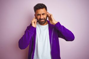 person-covering-ears-and-grimacing